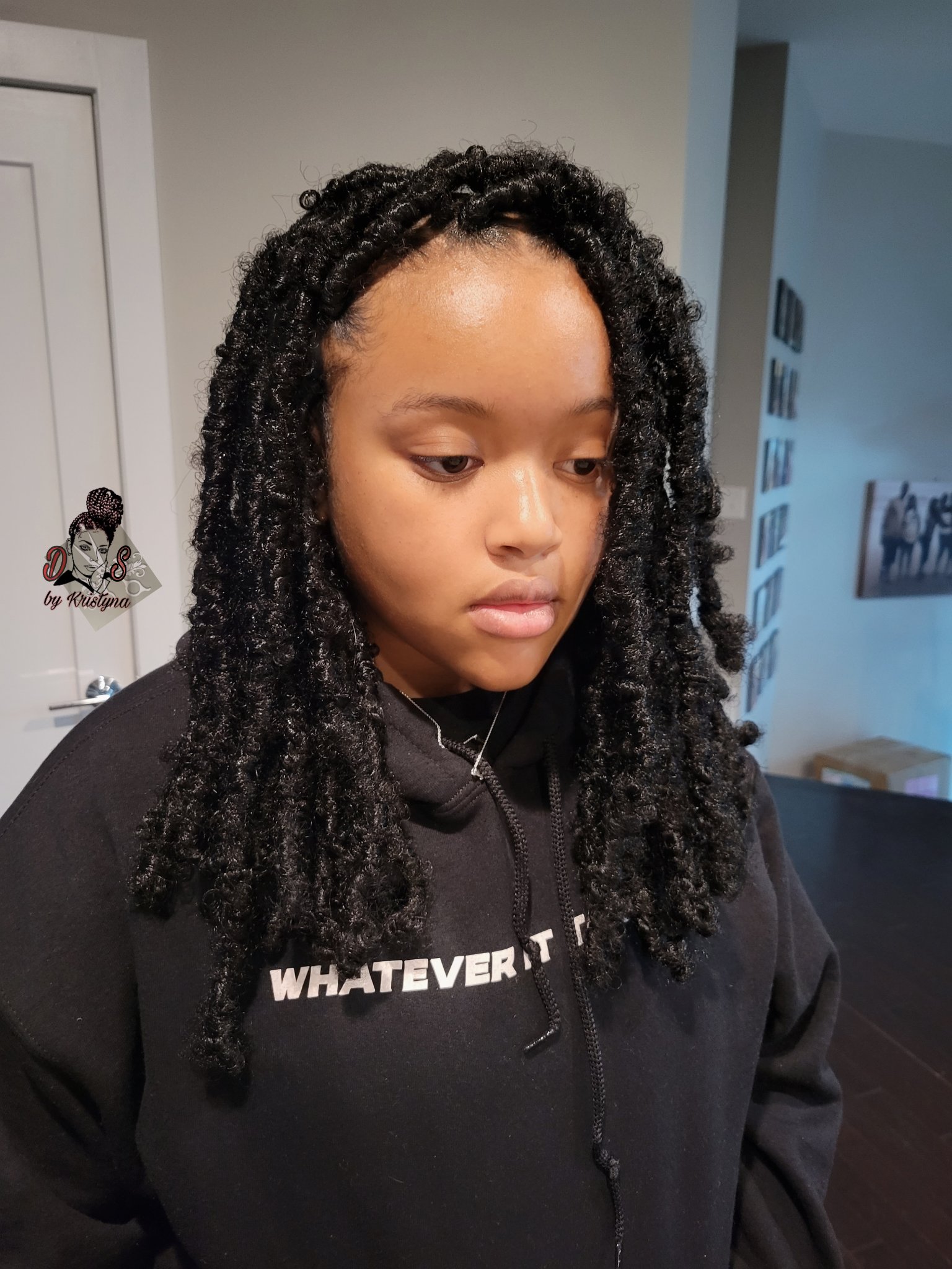 Butterfly locs in black, long and textured, framing the face, front view