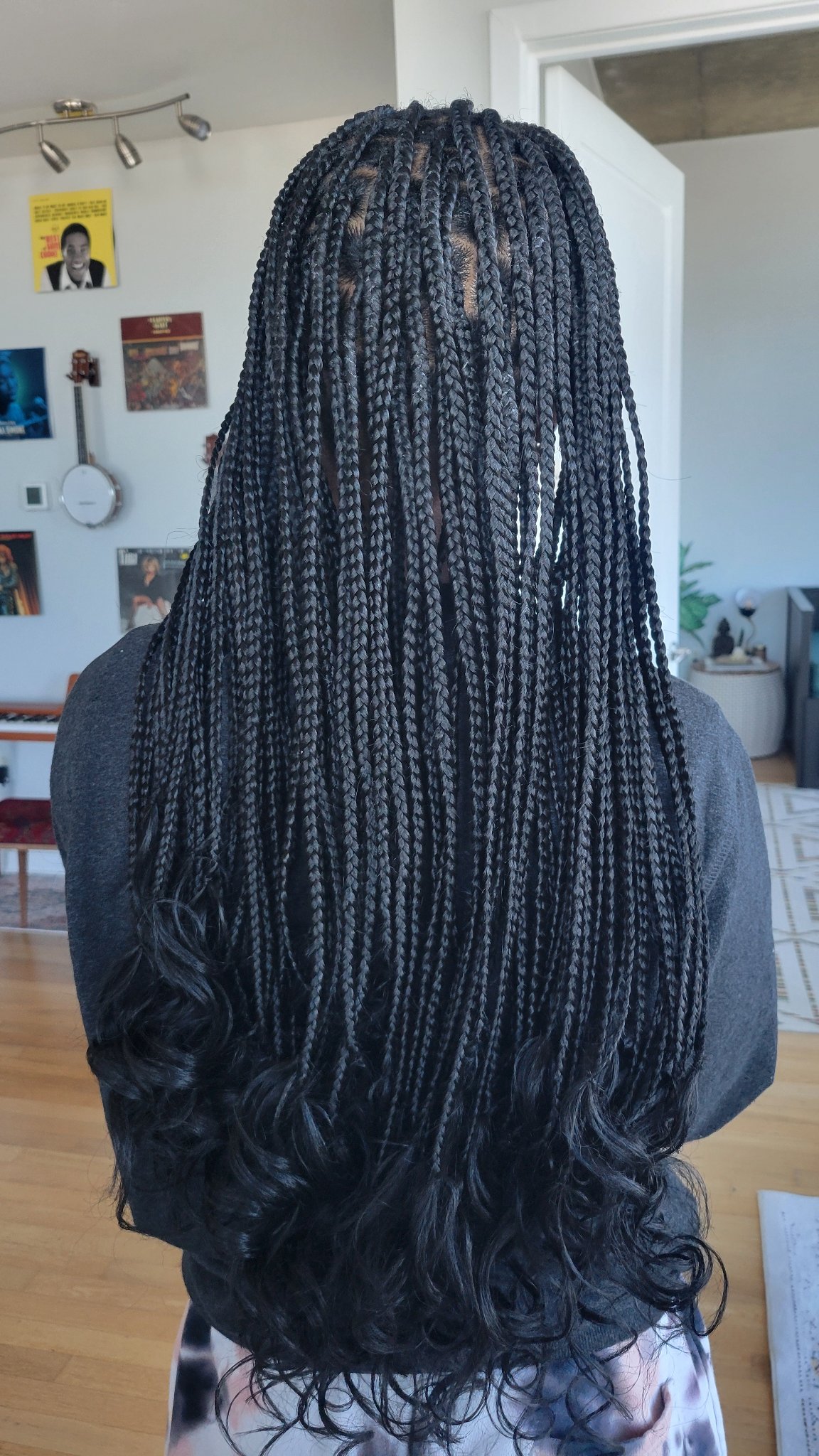 Long black knotless braids with curly ends, back view