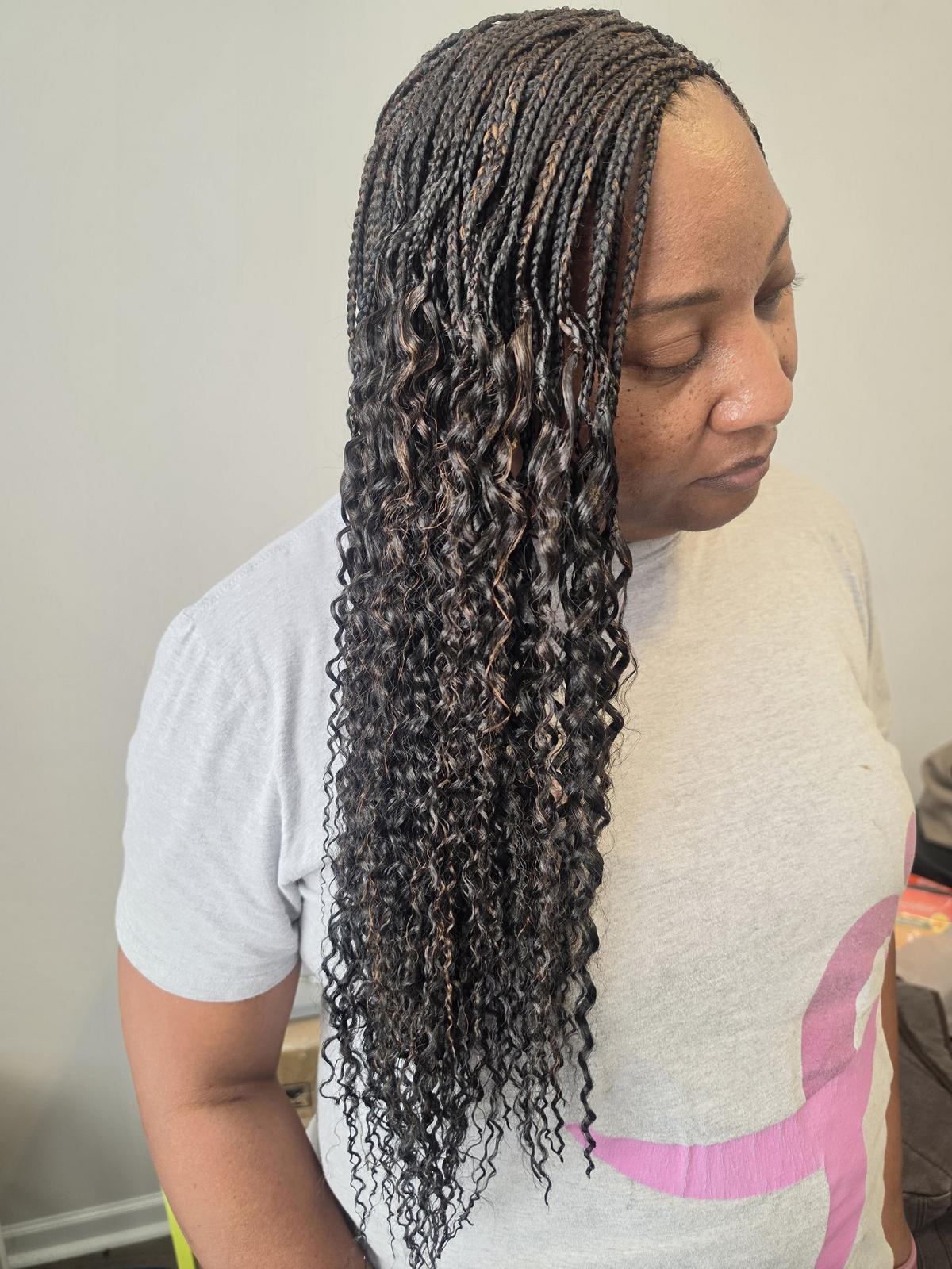 Micro braids with long curly ends in dark brown with caramel highlights, side view