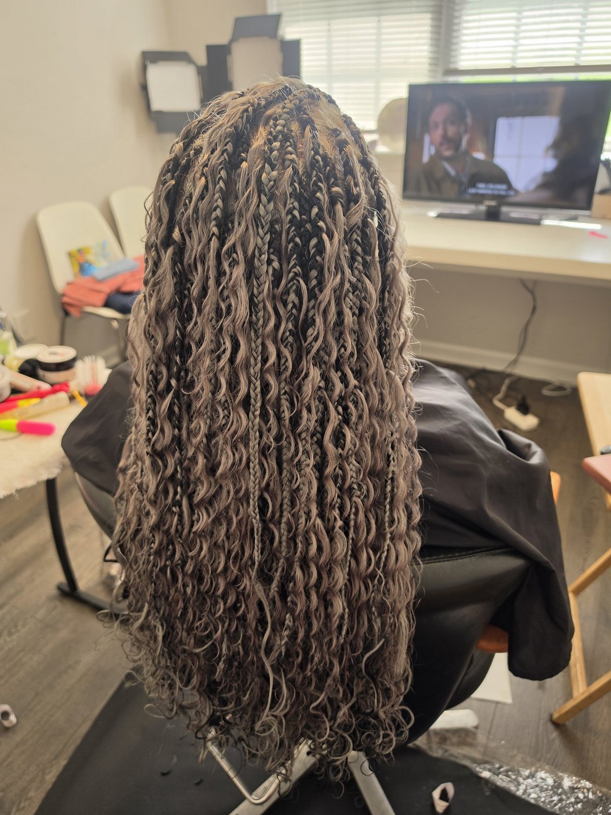 Boho box braids in a silver-grey tone with wavy curly ends